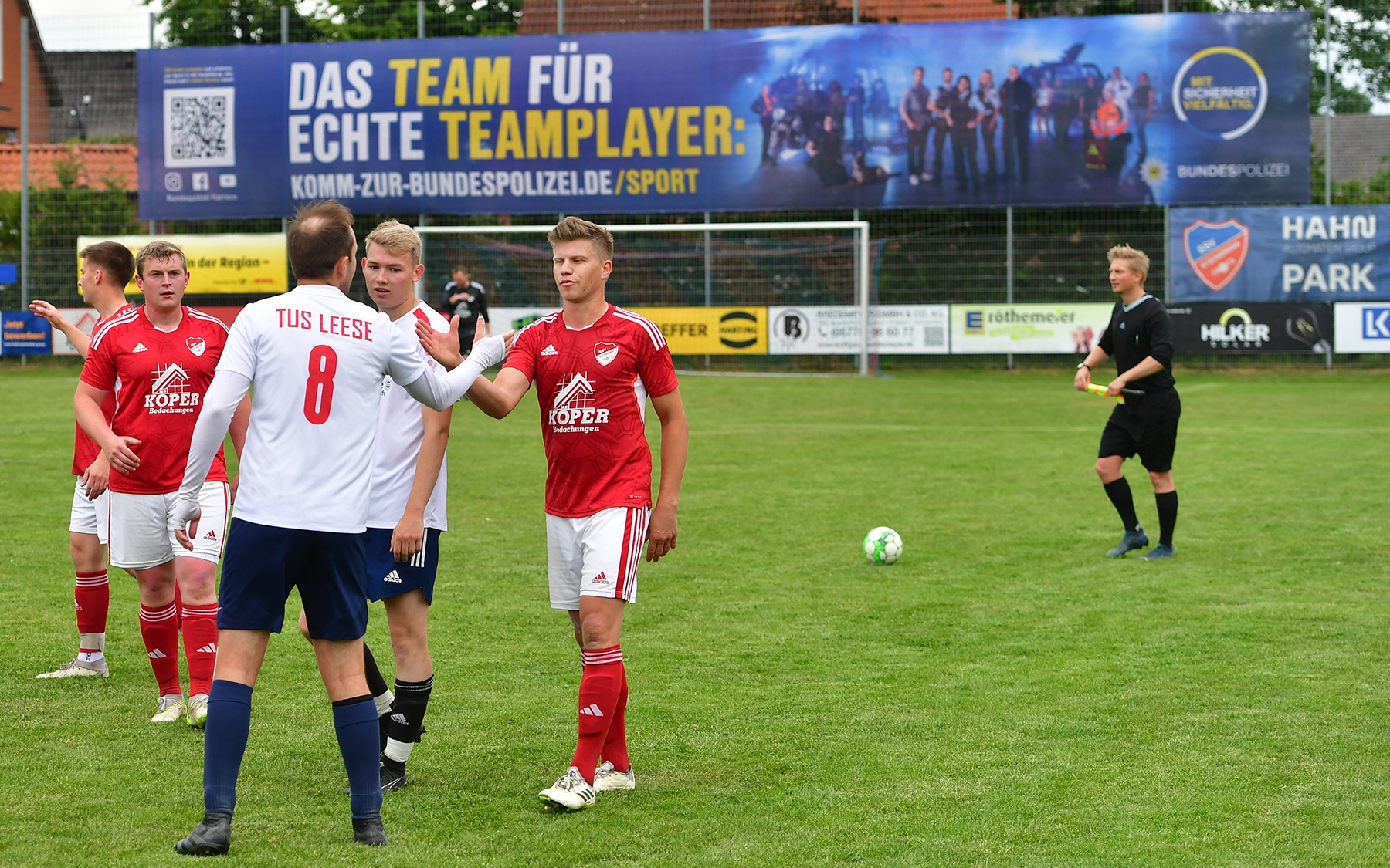 Freundschaftswerbung: Zwei Sportler gratulieren sich nach dem Spiel. Im Hintergrund sieht man Kampagnen von Anschlusstor. Freundschaft, Fußball und Prämie